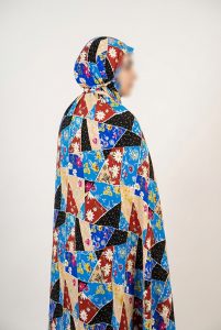 خانم با چادر نماز کیسهای طرح چهل تکه رنگی (سرمهای و قرمز) و جنس نخی کدری